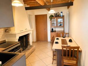 a kitchen with a fireplace and a table with chairs at Foxes house in Monte Fabbri