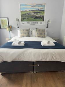a large bed with two towels on top of it at Wheatsheaf Inn in Brigsteer