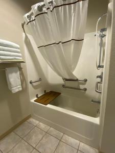 a bathroom with a bath tub with a shower curtain at Edmore Inn in Edmore +34 photos