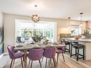 a kitchen and dining room with a table and purple chairs at Pennant in Llanerfyl