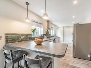 a kitchen with a large island with a bowl of fruit on it at Pennant in Llanerfyl +27 photos