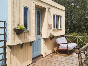 a wooden house with a chair on a deck at Rosie - Uk49025 in Pencarreg