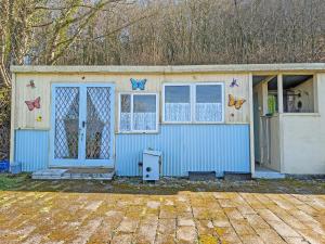a small blue building with butterflies on the door and windows at Rosie - Uk49025 in Pencarreg
