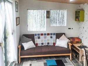a couch in a living room with two windows at Rosie - Uk49025 in Pencarreg