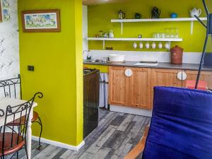 a kitchen with yellow walls and a blue chair at Rosie - Uk49025 in Pencarreg