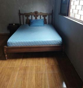 a small bed in a room with a wooden floor at Cantinho da Flor in Barretos