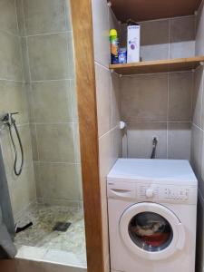 a small bathroom with a washing machine in it at studio colibri in Saint-François