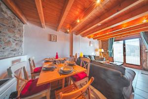 a dining room with a table and chairs and a couch at La Grange de la Petite Ourse in Les Angles