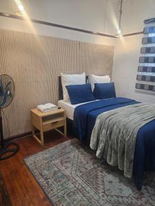 a bedroom with two beds with blue sheets and a table at Ludinz Accomodation Self Catering in Avondale +65 photos