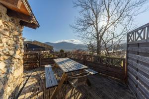 a wooden deck with a table and bench on it at La Grange de la Petite Ourse in Les Angles