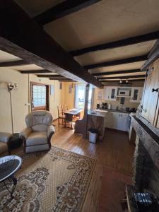 a living room with a couch and a kitchen at The Bell`s End Cottage in Notre-Dame-du-Touchet