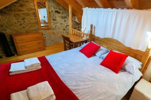 a bedroom with a bed with red and white pillows at La Grange de la Petite Ourse in Les Angles +37 photos
