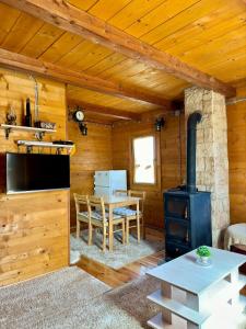 a kitchen and dining room in a log cabin with a stove at Vikendica Varde Žabljak in Žabljak