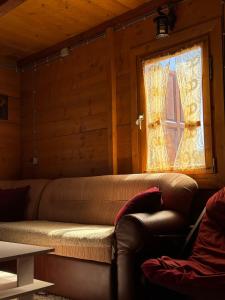 a couch sitting in a room with a window at Vikendica Varde Žabljak in Žabljak