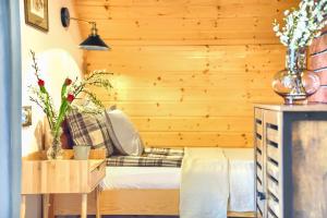 a bedroom with a bed and a wooden wall at Domki Mazurska Dolina in Mikołajki +116 photos