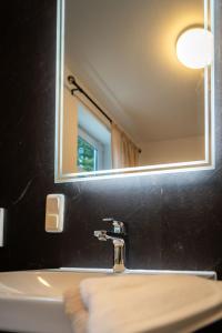 a bathroom with a sink with a mirror and aaucet at Ferienwohnung Zur Winkelgasse in Bad Langensalza +20 photos