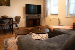 a living room with a couch and a tv at Ferienwohnung Zur Winkelgasse in Bad Langensalza
