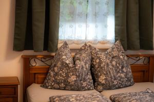a bed with two pillows sitting in front of a window at Ferienwohnung Zur Winkelgasse in Bad Langensalza