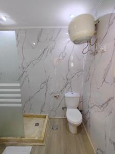 a bathroom with a toilet and a marble wall at Porto View in Hurghada +38 photos
