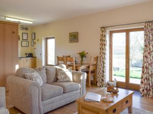 a living room with a couch and a table at Gwel-Y-Lyn in Mydroilin
