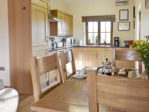 a kitchen with a table and chairs and a dining room at Gwel-Y-Lyn in Mydroilin