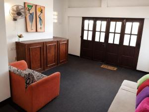 a living room with an orange chair and a door at Villa Yuvin in Matara
