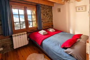 a bedroom with a bed with red pillows and a window at La Grange de Cassiopée in Les Angles +37 photos