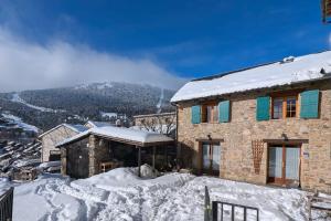 a house in the snow with a mountain in the background at La Grange de Cassiopée in Les Angles