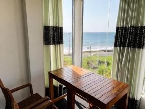 a dining room with a table and a view of the beach at Villa Yuvin in Matara
