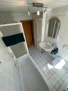 a white bathroom with a tub and a sink at Ferienwohnung Matthias Lang in Rugendorf +12 photos