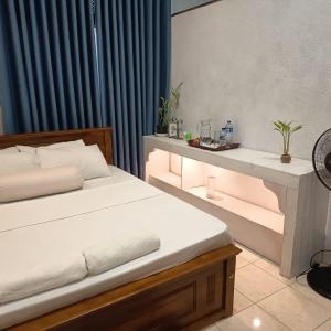 a bedroom with a bed and a table with lights at Pavani Villa Kandy in Peradeniya
