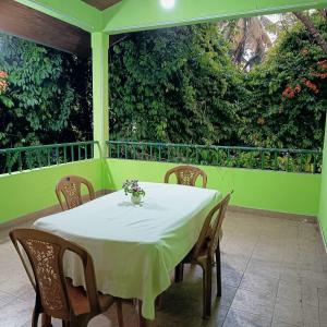 a white table with chairs on a green porch at Pavani Villa Kandy in Peradeniya