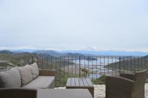 a patio with chairs and a table and a view of the water at Panorama Stone Houses - Skadar Lake in Cetinje