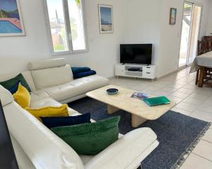 a living room with a couch and a tv at Villa Elara provençale avec piscine 4 étoiles in Sarrians