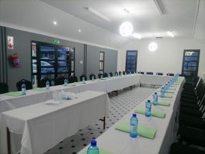a row of tables with bottles of water on them at Phomolo Guest House in Maseru