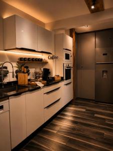 a kitchen with white appliances and a wooden floor at Ocean Eleven Boutique Stay - Sea View Sunset Terrace in Sainte-Anne +50 photos
