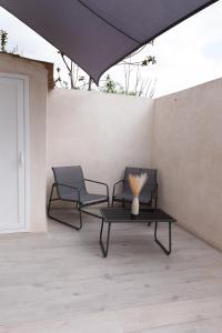 a patio with two chairs and a table with a vase on it at Civico Dodici in Modica +6 photos