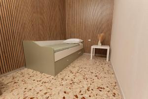 a small bedroom with a bed and a side table at Civico Dodici in Modica