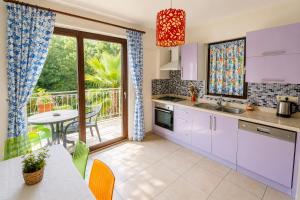 a kitchen with purple cabinets and a table and a dining room at Villa Garden Island in Dalyan