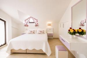 a white bedroom with a white bed and flowers at Villa Garden Island in Dalyan +14 photos
