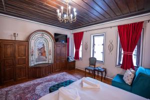 a living room with a bed and red curtains at RAHAT Guest House in Old Town - Free Private Parking in Plovdiv