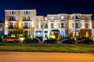 a large white building with cars parked in front of it at The Carlton Hotel in Folkestone