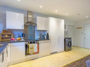 a kitchen with white cabinets and a dishwasher at The Bungalow in Dingwall
