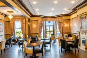 a restaurant with tables and chairs and windows at The Carlton Hotel in Folkestone