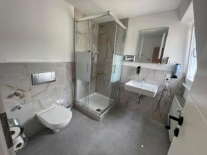 a bathroom with a shower and a toilet and a sink at Hotel & Restaurant Bella Italia in Niederfell