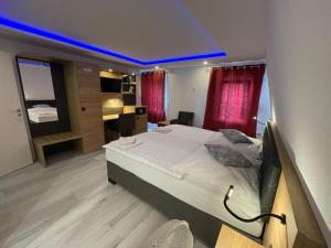 a bedroom with a large white bed with a blue ceiling at Hotel & Restaurant Bella Italia in Niederfell