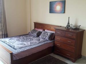 a bedroom with a bed and a dresser at Kalubowila Rooms in Dehiwala