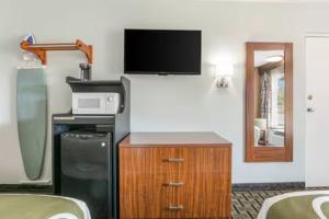 a room with a tv and a cabinet with a microwave at The Cherrywood Inn in Georgetown