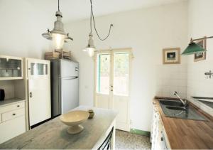 a kitchen with a white refrigerator and a table at Villa Casa Rosa in Procchio
