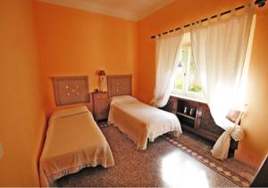a bedroom with two beds and a window at Villa Casa Rosa in Procchio